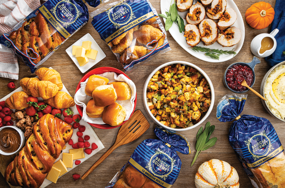 Brioche Gourmet brioche loaves, buns and rolls on a holiday brunch table with baked dishes and fall decor