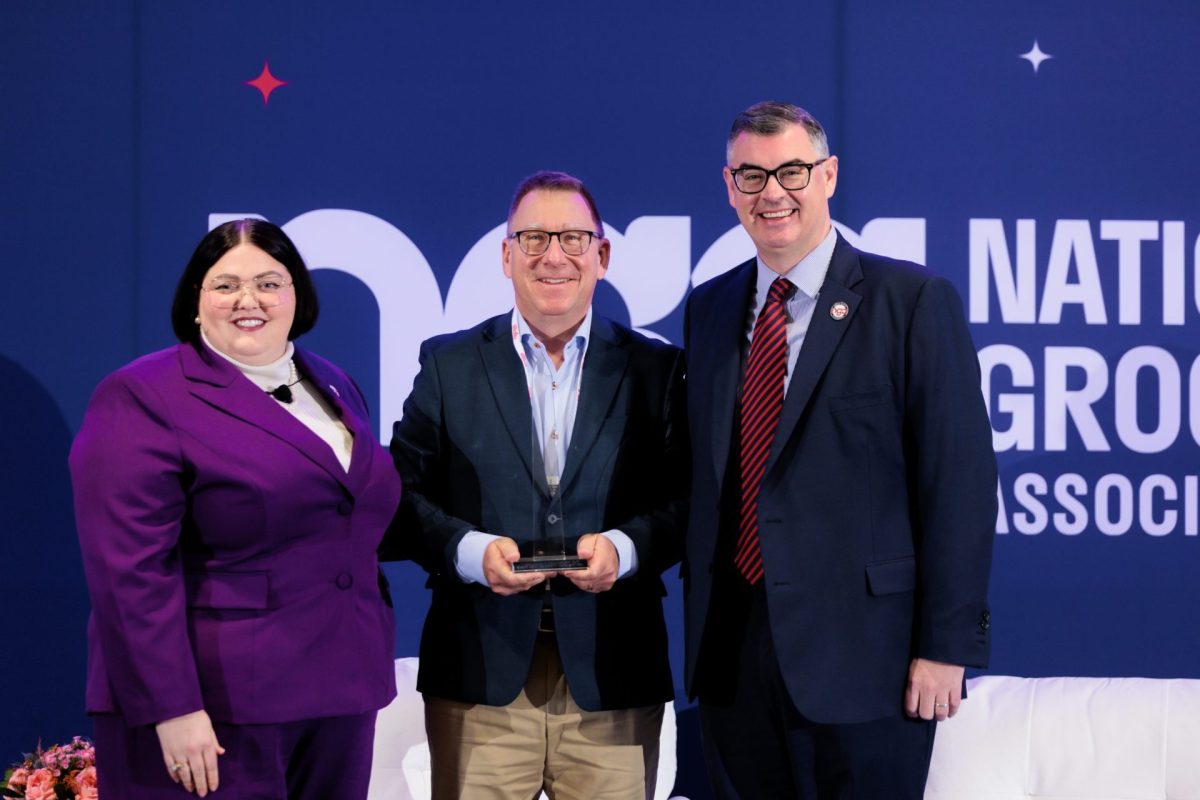 three people, award winner in center